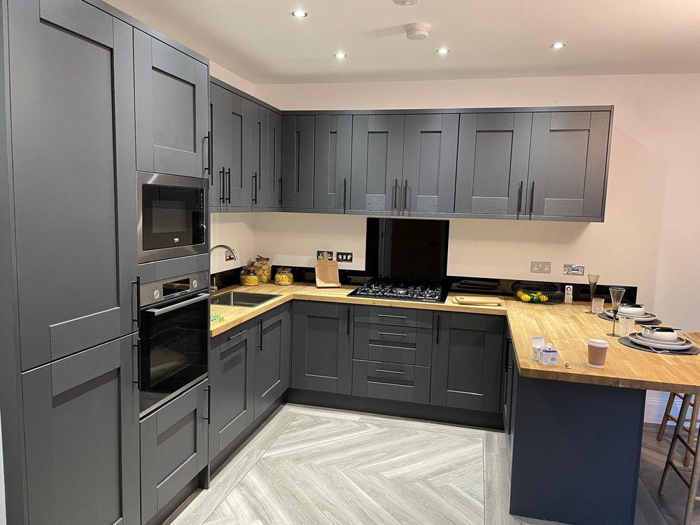 Grey shaker fitted kitchen with oak worktop